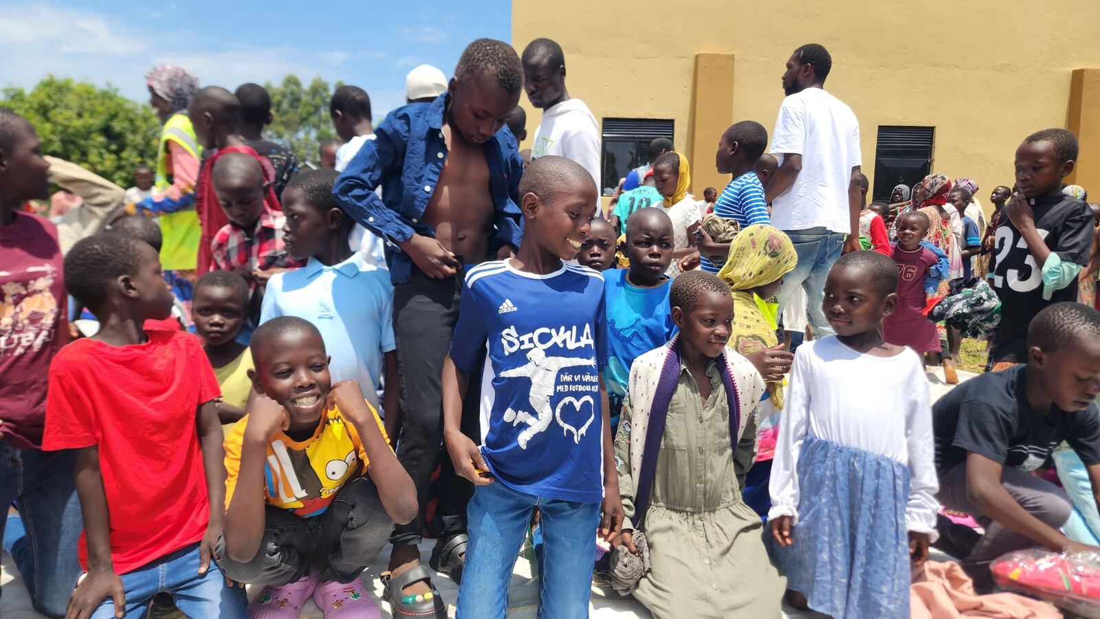 Children and community members gathered at a Good Will distribution site