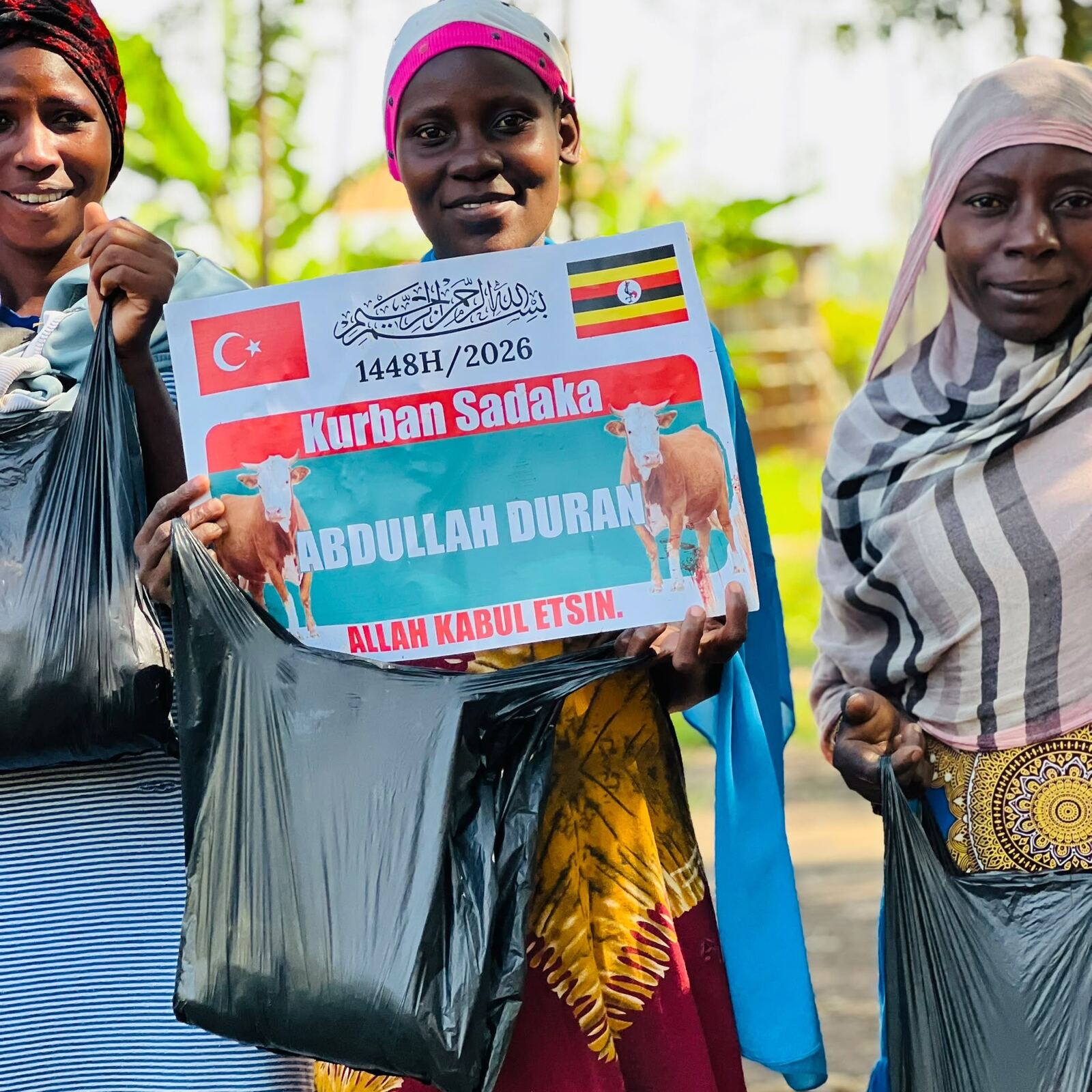 Women holding bags of distributed Qurban meat, marked with the donor's name